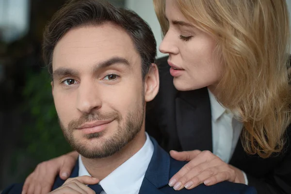 Woman stroking male shoulders. Passionate couple of two Caucasian business people. Close up portrait. Selective focus on male face. Flirt or love affair at job — Stock Photo, Image