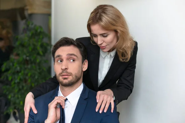 Jovem chefe do sexo feminino seduz empregado masculino. Mulher acariciando um homem ombros. Abuso do estado de trabalho. Empoderamento das mulheres, conceito de feminismo — Fotografia de Stock