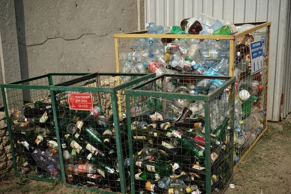 유리병과 플라스틱 병을 쓰레기통에 넣는다. 쓰레기를 분류하고 재활용하는 개념. 2018 년 8 월, 우크라이나 오데사 — 스톡 사진