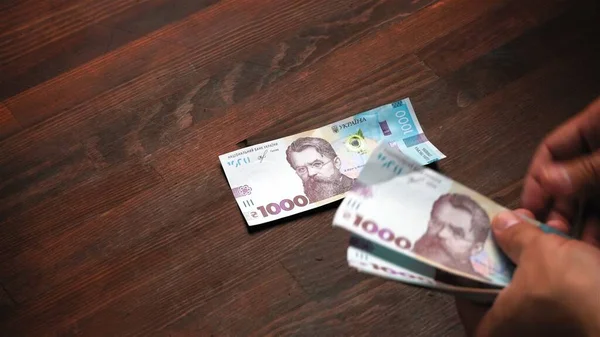 Kaukasischer Mann, der ukrainisches Papiergeld auf dem Markt betrachtet. Packung Papier Griwna in männlichen Händen. Inflationskonzept. Nahaufnahme — Stockfoto
