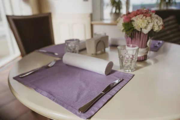 Bankettbord med blommor. Lätt festinredning på runt bord med rosenbukett i hem- eller restauranginredning. Bordsdekoration koncept. Romantiskt lunchkoncept — Stockfoto
