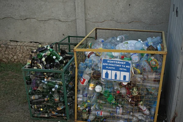 Classificação e reciclagem conceito de lixo. Garrafas vazias de vidro e plástico em diferentes recipientes de lixo. Agosto 2018, Odessa, Ucrânia — Fotografia de Stock