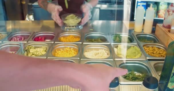 咖啡店的厨师做了一份外卖沙拉可供选择.游客选择产品。制作健康食品 — 图库视频影像