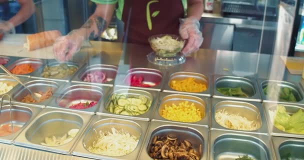 O chef do café faz uma salada takeaway para escolher. O visitante escolhe os produtos. Preparação de alimentos saudáveis — Vídeo de Stock