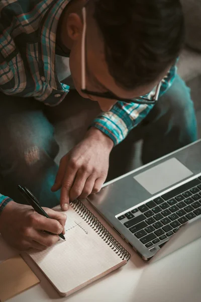 프리랜서 사업 컨셉. 젊은이는 직장에서 공책으로 글을 쓰고 있다. 남성 프리랜서는 집에서 일 한다. 위에서 내려다 본 확대 사진 — 스톡 사진