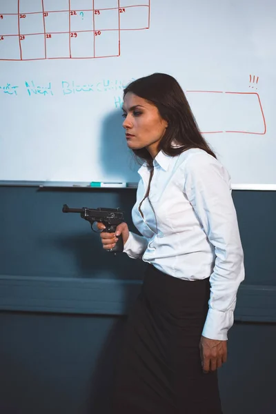 Loca mujer de negocios enojada con un arma en la oficina. Concepto de crisis empresarial. Concepto de armas. Imagen teñida — Foto de Stock