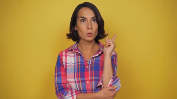 Mujer de mediana edad con el pelo corto marrón pensar en algo.. Mujer de pie sobre el fondo amarillo. Chica hacer algunos planes .Future planes. — Vídeos de Stock