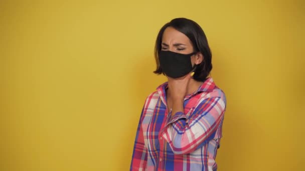 Középkorú, barna hajú nő fekete szennyezési maszkot visel. Karantén fogantatás. Mint egy jel. A lány köhögés torka fáj — Stock videók