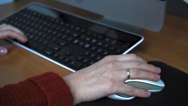 Dziewczyna pisze na klawiaturze. Praca w biurze to pojęcie. Kobiece ręce na klawiaturze. Ręka trzyma mysz. — Wideo stockowe