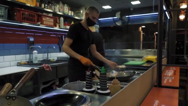 Cook make food for customer in cafe.Two chef protect themselves with mask and gloves . Quick healthy food. Outdoor life. Coronavirus and isolation conception. 7 of August 2020. Kyiv, Ukraine. — Stock Video