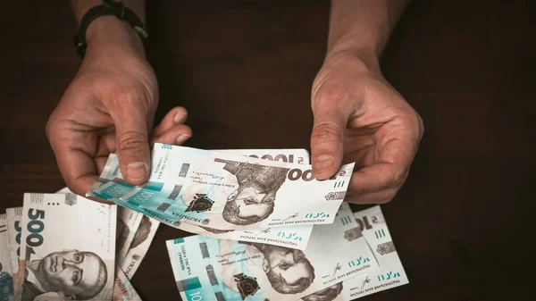 Mani maschili considera ucraino carta moneta, 1000 e 500 grivna. Concetto di credito. Concetto di cassa — Foto Stock