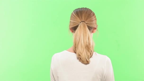 Блондинка середнього віку жінка позує і посміхається на зеленому екрані. Концепція природної краси. Коротке здорове сяюче волосся. Дівчина підтягує волосся — стокове відео