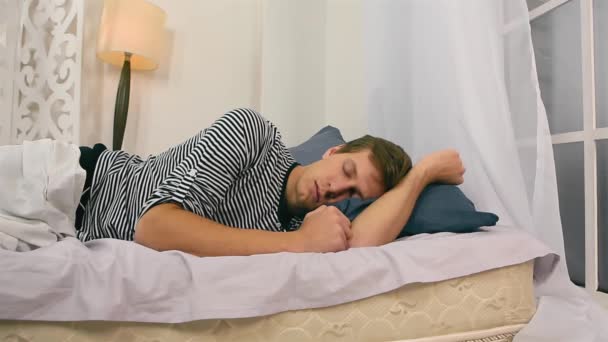 Weiße kaukasische junge Mann schlafen auf dem schlechten. Entspannte Konzeption. Aufwachen mit Wecker — Stockvideo