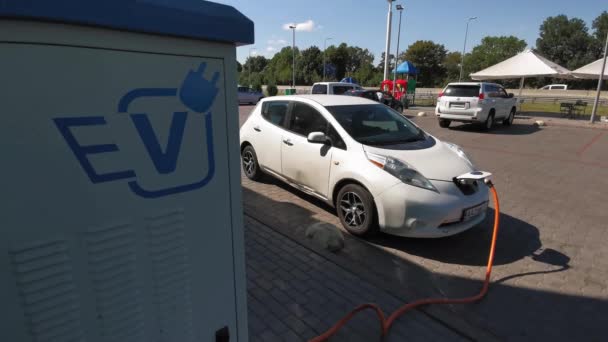 Οικολογική εναλλακτική έννοια της ενέργειας. Ηλεκτρικό αυτοκίνητο στο σταθμό φόρτισης με το καλώδιο τροφοδοσίας συνδεδεμένο. Κινητό βίντεο. 3 Αυγούστου 2020. Κίεβο, Ουκρανία. — Αρχείο Βίντεο
