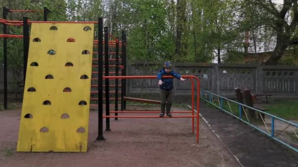 Little cute boy in blue jacket play on the pull up bar for children. Joy and happiness. Healthy lifestyle. Playing in the city mobile video. 8 of June 2020. Kyiv, Ukraine. — Stock Video