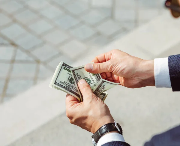 Mens hands hold dollars. Successful businessman considers salary.Male arms with watch, close up shot. High quality photo — Stock Photo, Image