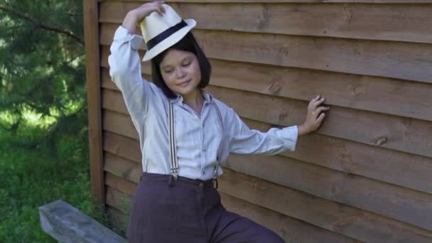 Mladá žena v širokých kalhotách s podvazky si sundá klobouk a nasadí si ho. Country styl v oděvním konceptu. Kvalitní 4K záběry. 29. srpna2020. Kyjev, Ukrajina — Stock video