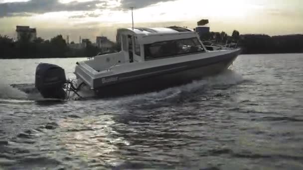 Båt med motorn svänger smidigt på vattnet, skapar vågor. Sprutar från motorn. Hög kvalitet. 27 juli 2020. Kiev, Ukraina — Stockvideo