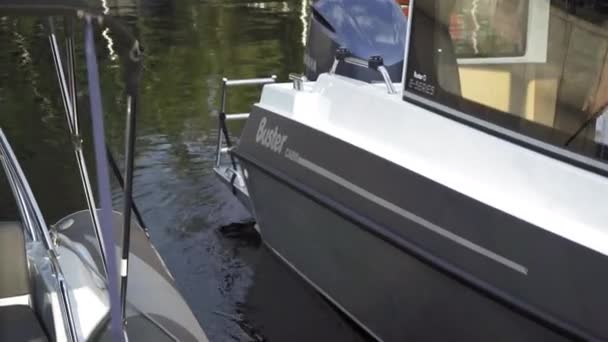 Aangemeerde boot met een motor zwaait op het water. Boten staan naast de pier. Hoge kwaliteit. 27 juli 2020. Kiev, Oekraïne — Stockvideo