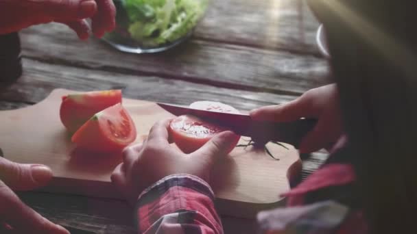 Ungen lär sig att skära tomat. Föräldrar och barn befruktning. Köksutrymme — Stockvideo