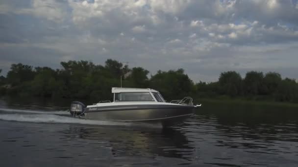 Barca naviga lungo il fiume fuori città. Tempo nuvoloso e foresta sullo sfondo. Di alta qualità. 27 luglio 2020. Kiev, Ucraina — Video Stock