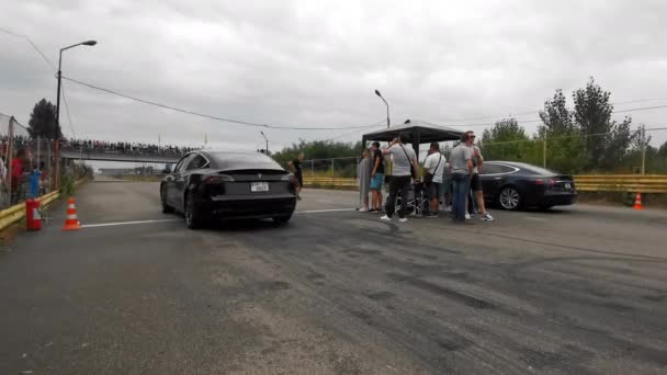Dos coches eléctricos Tesla comienzan desde la línea. Los operadores filman la carrera. Alta calidad. 24 de agosto de 2020. Kiev, Ucrania — Vídeos de Stock