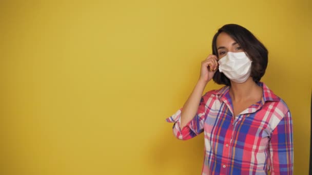 Jonge vrouw met bruin haar agressief nemen van witte vervuiling masker. Quarantaine conceptie. Net als teken. Videoclip