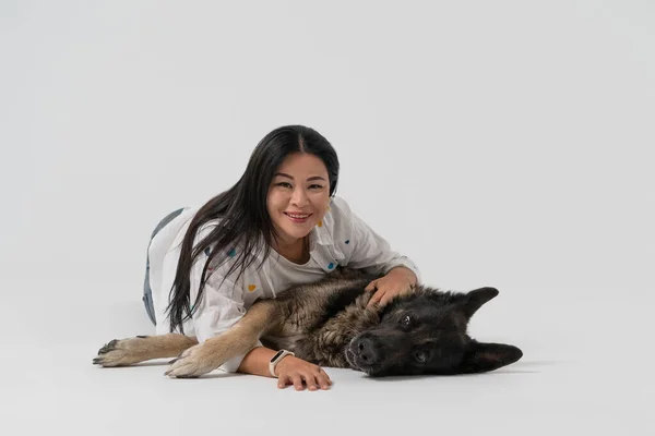 Gelukkige vrienden. Schoonheidsvrouw en herdershond kijkt naar camera omhelzend samen in studio. Uitgesneden op witte achtergrond. Vriendschapsconcept — Stockfoto