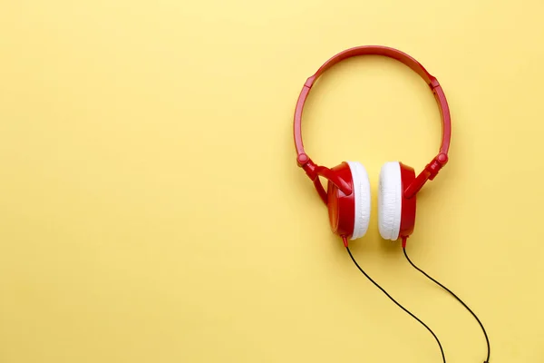 Foto de vermelho com fones de ouvido brancos para música em fundo amarelo limpo — Fotografia de Stock