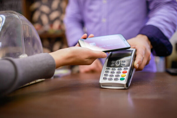 Image of seller with terminal and buyer with smartphone