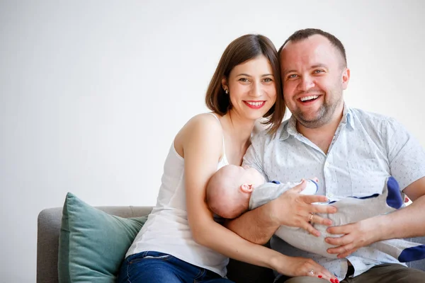 婴儿坐在沙发上的快乐父母照片 — 图库照片