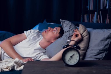 Brunet ile çalar saat yatakta yalan uykusuzluk ile portresi
