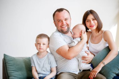 Çift kanepede oturan iki genç oğlu ile