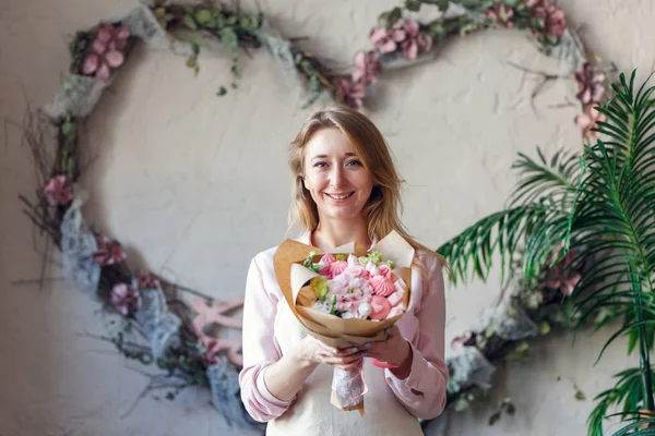 Retrato de florista sonriente con ramo en las manos — Foto de Stock