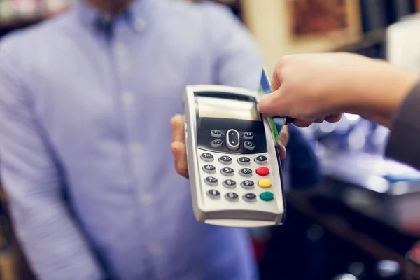 Image du vendeur avec terminal dans les mains et acheteur avec carte bancaire . — Photo