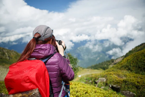 Image of photographer girl with backpack backdrop of mountains — Stock Photo, Image