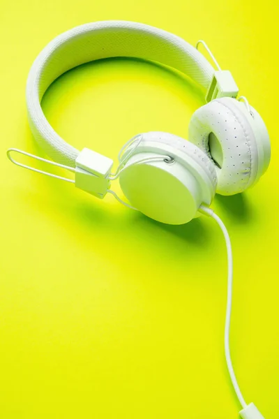 Headphone putih dengan kabel pada latar belakang kuning kosong . — Stok Foto