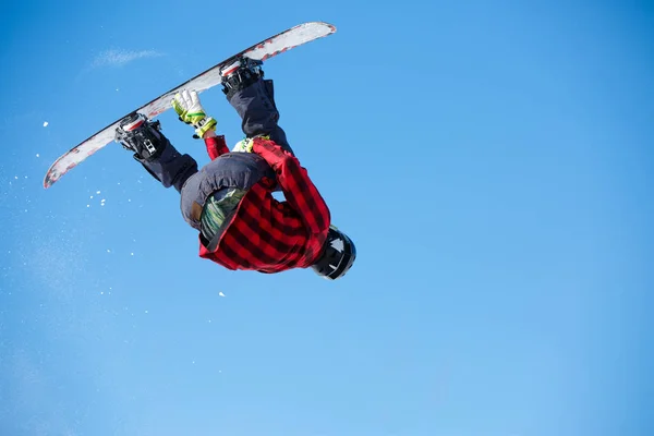 Foto de baixo de homem pulando com snowboard e céu azul claro — Fotografia de Stock