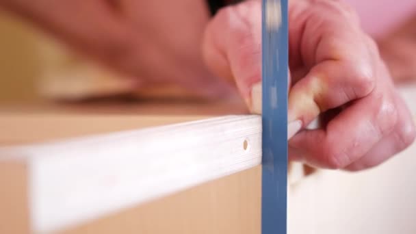 Primer plano de una persona anónima usando una sierra de mano en el taller para cortar un trozo de madera contrachapada con una sierra de mano . — Vídeo de stock