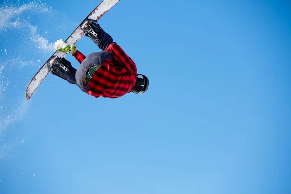 Imagem de baixo do homem pulando com snowboard e céu azul claro — Fotografia de Stock