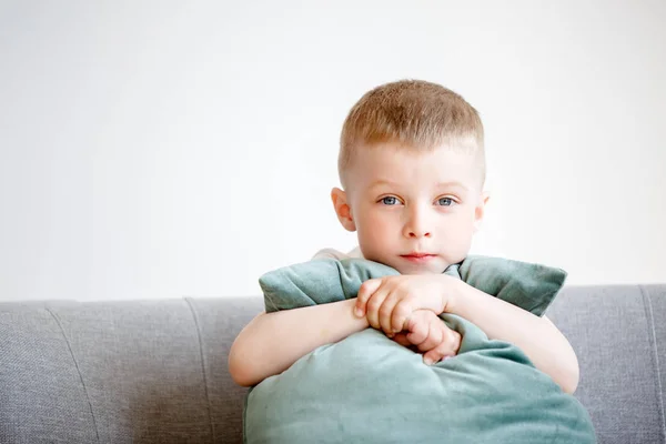 Porträtt av pojke med kudde som sitter på soffan — Stockfoto