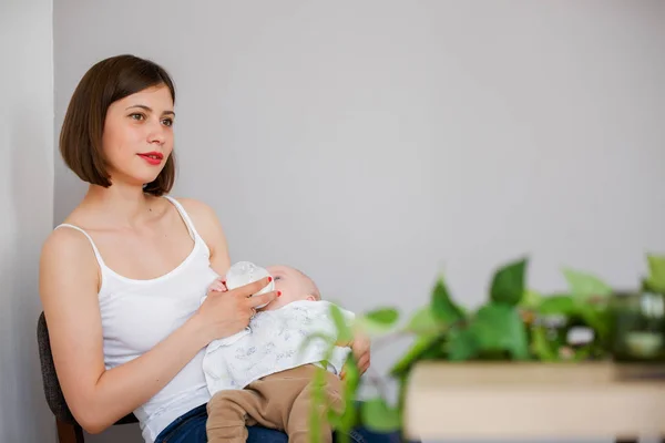 Foto de madre feliz alimentando a su hijo con leche de biberón — Foto de Stock