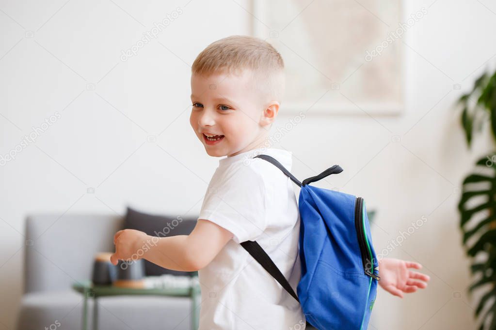 Image of boy with backpack near sofa