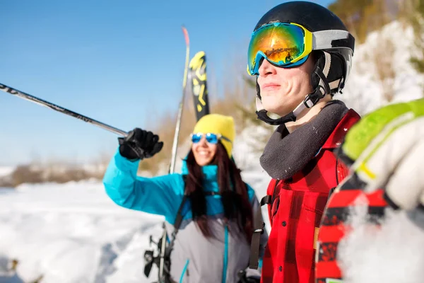 Photo de sportif homme et femme pointant vers l'avant marchant sur une colline de neige — Photo