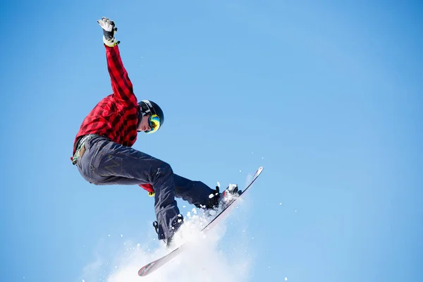 Foto de un joven deportista saltando con snowboard —  Fotos de Stock