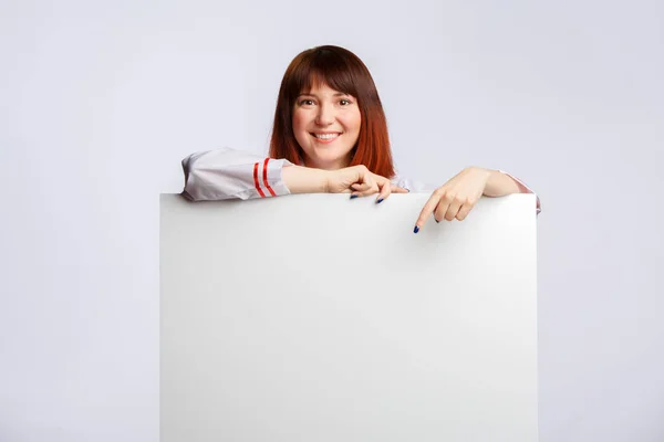 Obrázek ženské Cook v bílém plášti s prázdnou plakát — Stock fotografie