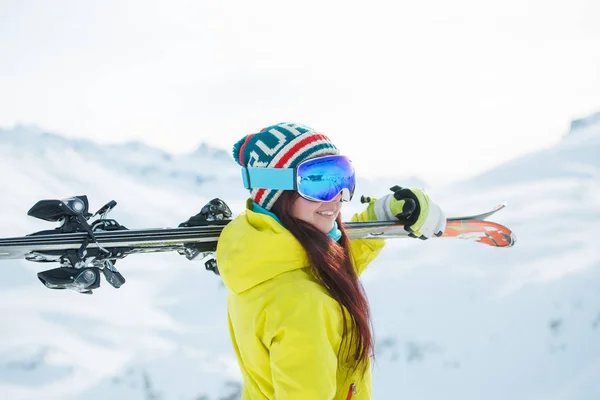 Side view of smiling woman in mask with skis on her shoulder — Stock Photo, Image