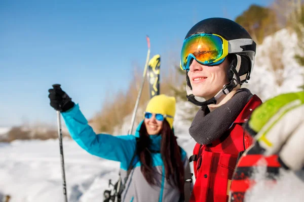 Imagen del hombre y la mujer deportivos señalando hacia adelante caminando sobre la colina de nieve —  Fotos de Stock