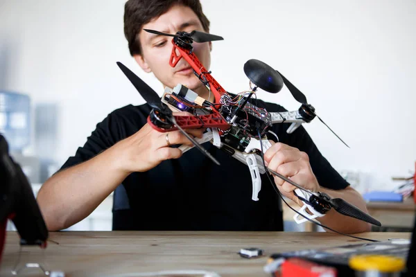 Picture of man fixing square copter at table — Stock Photo, Image