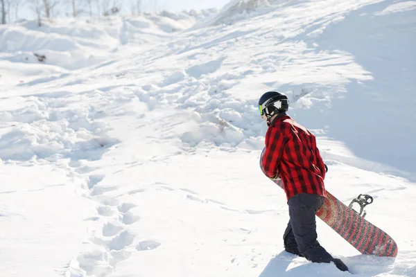 Photo of man with snowboard walking on snowy mountain slope — Stock Photo, Image